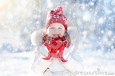 Child drinking hot chocolate in winter park. Kids in snow on Christmas. Stock Photo