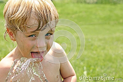 Child Drinking Water from Hose Stock Photo