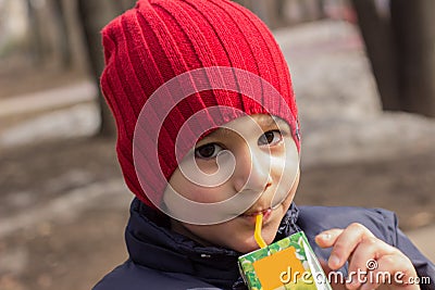 The child drinks juice in the Playground. emotional close-up portrait. Stock Photo