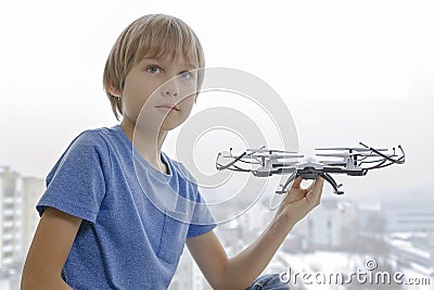 Child with drone against window at home. Technology, leisure toys concept Stock Photo