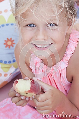 Child eating a flat peach Stock Photo