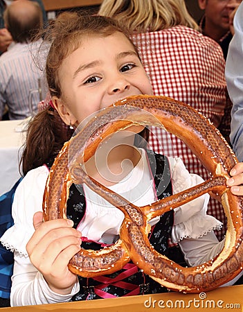 Child eating pretzel at Oktoberfest, Munich, Germany Stock Photo