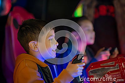 The child emotionally plays on gaming machines in entertainment Stock Photo