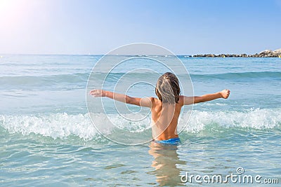 Child enjoying sun and waves Stock Photo