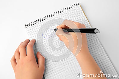 Child erasing doodle drawn with erasable pen in notepad against white background, top view Stock Photo