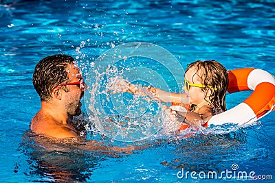 Child and father playing in swimming pool Stock Photo