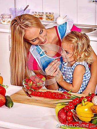Child feed mother at kitchen Stock Photo