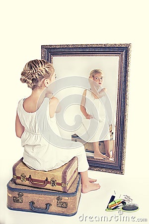 Child fixing her hair while looking in the mirror. Stock Photo