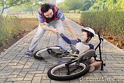 Child gets crash and helped by dad Stock Photo