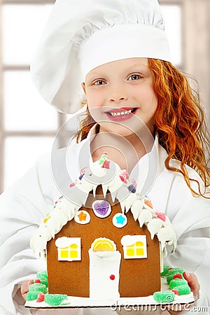 Child with Gingerbread House at Christmas as Chef Stock Photo