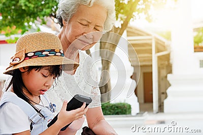 Child girl is addictive, have an elderly grandmother sit Stock Photo