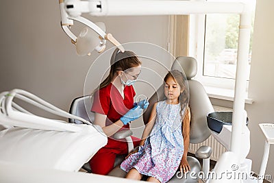 Child girl afraid dentist. Childrens dentist consults frightened kid in dentistry. Treatment of teeth and toothache in Stock Photo