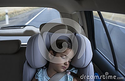 Child girl asleep in a child safety seat in a car Stock Photo