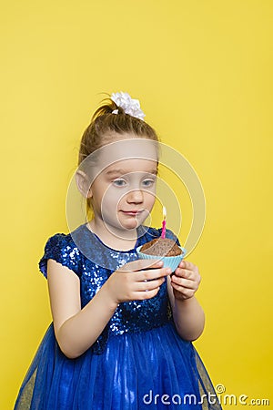 Child Girl blows out a candle on a cupcake and makes a wish. Happy birthday or make a wish concept Stock Photo