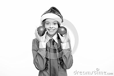 Child girl on christmas new year isolated in white studio background. Teenager hold christmas ball bauble in santa hat Stock Photo