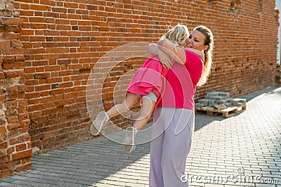 Child girl with cochlear implant with her mother spend time outdoor. Hear impairment and deaf community concept. Deaf Stock Photo