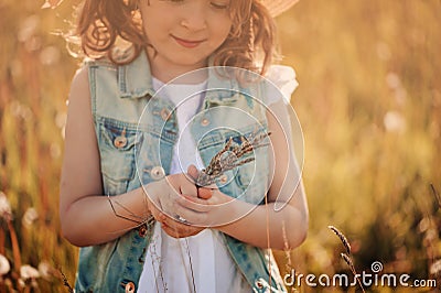 Child girl on cozy walk on warm summer field on vacation Stock Photo