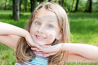 girl with deep blue eyes in green sunny park Stock Photo