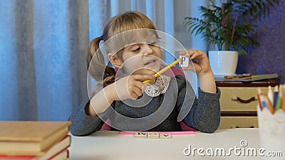 Child girl doing school homework teach alphabet letters with teacher at home, video call by webcam Stock Photo