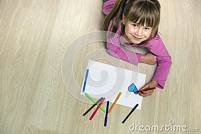 Child girl drawing with colorful pencils crayons heart on white paper. Art education, creativity concept Stock Photo