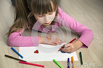 Child girl drawing with colorful pencils crayons heart on white paper. Art education, creativity concept Stock Photo