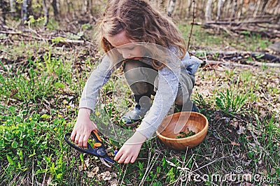 Child girl exploring nature in early spring forest. Kids learning to love nature. Teaching children about seasons changing. Stock Photo