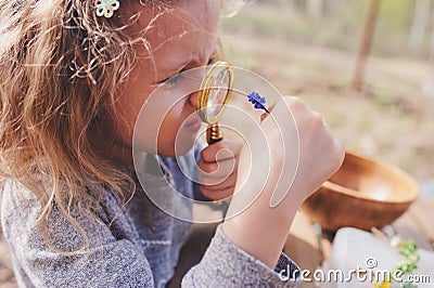 Child girl exploring nature in early spring forest. Kids learning to love nature. Teaching children about seasons changing. Stock Photo