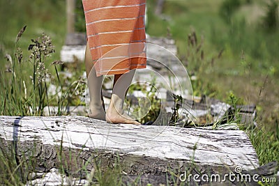 Child girl feet walking barefoot, standing on tree trunk Stock Photo