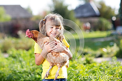 Child with hen in hands in rural Stock Photo