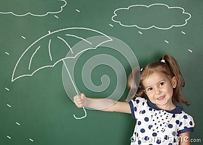 Child girl hold umbrella near school blackboard, weather concept Stock Photo