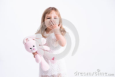 Child girl hugging her pink teddy bunny sending a kiss on white background. Cute girl with her toy Stock Photo