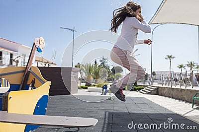 Child girl jumping from Walking the plank of playground pirate ship Stock Photo