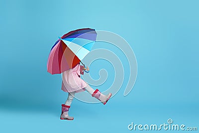 Child girl with multicolored umbrella in pink rain coat Stock Photo