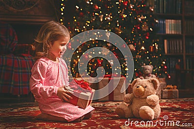 Child girl in nightgown with teddy bear in Christmas night Stock Photo