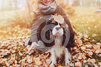 Child girl playing with her dog in autumn garden on the walk Stock Photo