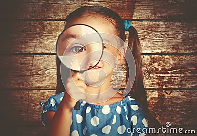 Child girl playing with magnifying glass in detective Stock Photo