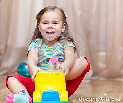 Child girl playing with a toy car Stock Photo