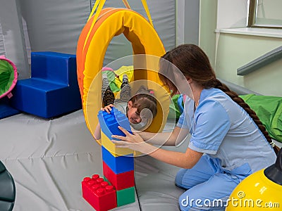 Child girl in roller tonnel during sensory integration session Stock Photo