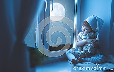 Child girl at window dreaming starry sky at bedtime Stock Photo