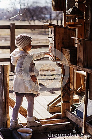 Child girl with wooden bird houses on country side Stock Photo