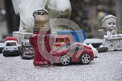 Child grave in the cemetery. Angels, toys, cars concept: death, loss Stock Photo