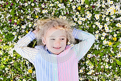 Child on green grass lawn with summer flowers Stock Photo