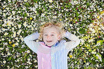 Child on green grass lawn with summer flowers Stock Photo