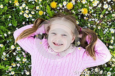 Child on green grass lawn with summer flowers Stock Photo