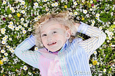 Child on green grass lawn with summer flowers Stock Photo