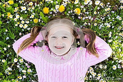 Child on green grass lawn with summer flowers Stock Photo