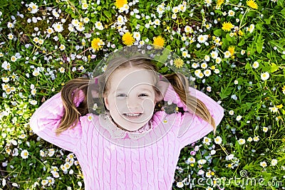 Child on green grass lawn with summer flowers Stock Photo