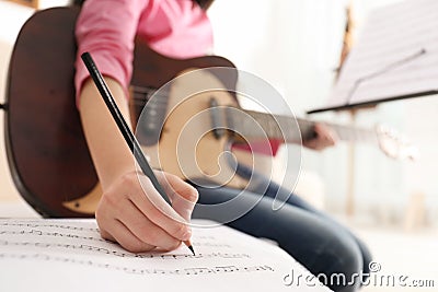 Child with guitar writing music notes at home Stock Photo