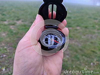 Child hand holding a compass, in a foggy day Stock Photo