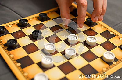 Child hand playing checkers board game. Black and white. Stock Photo